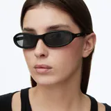 Lentes de sol con montura envolvente de diseño aerodinámico en color negro brillante y cristales oscuros polarizados.