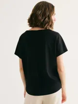 Blusa negra de manga corta con cuello redondo y calce holgado.