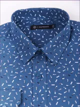 Camisa de manga larga marca Cuatro Ases, color gris con estampado de pequeños triángulos blancos. Presenta cuello clásico, cierre frontal con botones y puños abotonados.