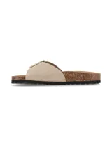Sandalias Hush Puppies de cuero gamuzado en color taupe, con tira ancha ajustable mediante una hebilla metálica dorada grande. Poseen una plantilla anatómica revestida en corcho y una suela de goma texturizada en color negro.