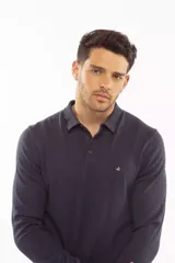 Sweater de punto estilo polo, color azul marino, con cierre frontal de botones, mangas largas y puños acanalados. Presenta un logo bordado en el pecho.