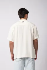 Camisa de manga corta con cuello cubano, confeccionada en lino entramado de textura natural. Presenta un corte relajado y cierre frontal con botones.