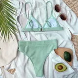Bikini de dos piezas color verde agua, confeccionado en tela acanalada. La parte superior es de estilo triángulo con breteles finos, y la parte inferior es de tiro alto con corte clásico.