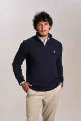 Sweater de punto acanalado color azul marino, con cuello alto y cierre frontal parcial. Presenta el logo de la marca bordado en el pecho y puños con terminación elástica.