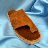 Sandalias tipo ojotas color marrón, confeccionadas en cuero con grabado sutil.