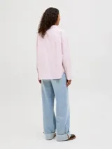Camisa de popelín blanca de manga larga con cuello clásico y cierre frontal de botones ocultos, de ajuste relajado y puños anchos.