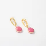 Caravanas colgantes con diseño de eslabón ovalado en metal dorado y dije circular con piedra natural en tono rosado.