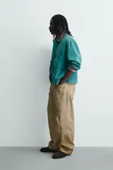Pantalón straight fit de algodón con efecto lavado y roturas localizadas. Presenta diseño de cinco bolsillos, cierre frontal con cremallera y botón metálico.