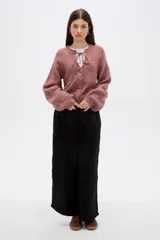 Saco de punto con textura, color rosado, con cuello a la base, cierre frontal con botones y detalle de cordón para anudar en el cuello. Presenta mangas largas con puños ajustados.