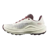 Championes de trail running Salomon Genesis 2, en color beige claro con detalles en bordó y rojo. Cuentan con capellada de Matryx®, sistema de ajuste rápido de cordones Quicklace, suela Contagrip® y tecnología Active Chassis para mayor estabilidad.