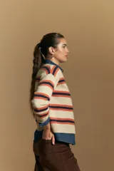Cardigan de punto con diseño de rayas horizontales en tonos marrón, rosa y beige. Presenta cuello redondo, cierre frontal con botones y mangas largas con puños acanalados.