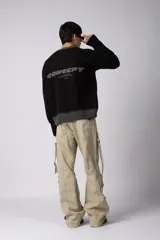 Sweater de punto acanalado con diseño degradado de negro a gris en el cuello y el ruedo. Presenta un corte regular y un pequeño bordado central en el pecho.