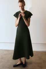 Vestido largo de punto en color verde oscuro jaspeado, con cuello redondo, manga corta y falda con corte evasé.