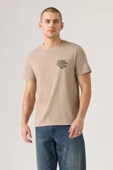 Remera de manga corta color beige, con cuello redondo y un pequeño estampado gráfico en el pecho.