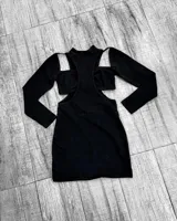 Minivestido negro ajustado con cuello alto, mangas largas y aberturas en hombros y cintura.