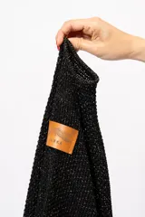 Ruana negra con lurex dorado, de corte cuadrado y mangas 3/4.