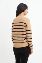 Sweater de punto color crema con rayas horizontales azul marino, cuello redondo y media botonadura frontal con botones marrones.