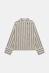 Camisa de corte oversize confeccionada en mezcla de viscosa, con estampado de rayas verticales. Presenta cuello solapa, cierre frontal con botones y mangas largas con puños amplios.