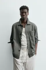 Sobrecamisa de hombre, color verde militar, con cuello solapa, manga larga y cierre frontal de botonadura. Presenta un bolsillo de plastrón en el pecho y bolsillos laterales en la cadera. El tejido tiene un efecto lavado.