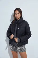 Campera puffer de nylon color marrón oscuro, con cuello alto, cierre frontal y puños elásticos. Diseño acolchado de volumen ligero.