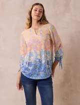 Blusa de modal estampada con cuello redondo y escote en V con aplique metálico. Mangas 3/4 con lazo.