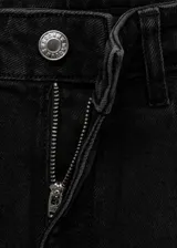 Pantalón de jean estilo flare de tiro medio, con cierre frontal de cremallera y botón, diseño de cinco bolsillos y acabado con bajo desflecado.