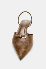 Zapato destalonado color marrón con efecto desgastado, punta fina, tira trasera ajustable y tacón fino de 7 cm.