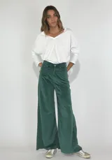 Pantalón de terciopelo gris, de corte palazzo, con bolsillos laterales y cierre frontal con botón y cremallera.