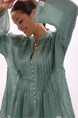 Camisa azul con cuello mao, abotonada al frente y mangas largas.