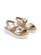 Sandalia de cuero metalizado color dorado con dos tiras de ajuste con velcro y plataforma baja de poliuretano blanco.