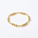 Pulsera elástica con cuentas doradas de diferentes tamaños.