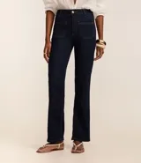 Pantalón de jean azul oscuro, de corte recto y tiro medio. Presenta bolsillos delanteros con costuras contrastantes y cierre frontal con botón y cremallera.