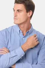 Camisa celeste con estampado a cuadros, de manga larga, con cuello abotonado, bolsillo en el pecho y logo bordado.