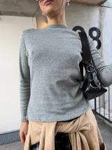 Remera básica de manga larga en color gris melange, con escote bote y ajuste ceñido al cuerpo.