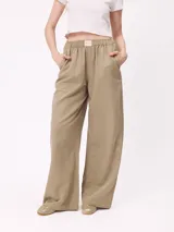 Pantalon de gabardina de corte ancho, color beige, con cintura elastizada y bolsillos laterales.