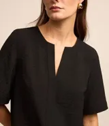 Blusa negra con escote en V, manga corta y textura airflow.