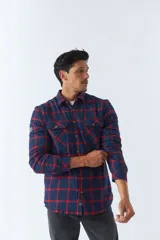 Sobrecamisa de algodón a cuadros color ladrillo, con interior de corderito, cierre con botones, bolsillos tipo cartera y logo en goma. El modelo usa talle M.