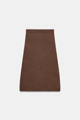 Falda midi de punto color crudo, con tiro medio, cintura elástica y diseño evasé.