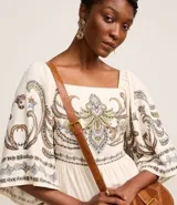 Vestido evasê midi confeccionado en viscolino, con mangas amplias, escote cuadrado en el busto y en la espalda, recorte en la cintura, lastex en la espalda y estampa de arabescos con estilo étnico en el tronco, mangas y en la bajo.