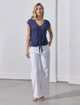 Blusa color beige de modal con escote en V, abertura central con botones y ruedo anudado. Marca French Laundry.