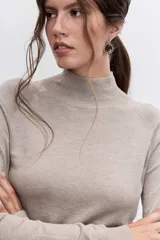 Jersey de punto fino en color negro, con cuello alto y mangas largas ajustadas.