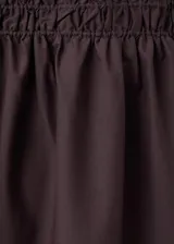 Falda midi color marrón oscuro con cintura elástica fruncida y silueta evasé.