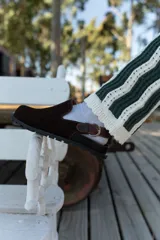 Zuecos de cuero marrón con talón descubierto y suela de goma.