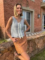 Musculosa tejida en lurex, color gris claro y blanco, con escote en V tanto en el frente como en la espalda. Presenta un detalle deshilachado o con flecos en el centro del frente.