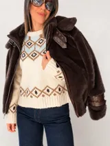 Campera de piel sintética color chocolate con capucha oversize. Presenta cierre frontal metálico, detalles en material engomado, cuello alto con doble hebilla y correas ajustables en los puños.