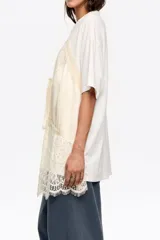 Camiseta de corte oversize con escote redondo y mangas cortas, que incorpora un top de satén y encaje superpuesto con diseño de tirantes finos y detalle de lazo frontal.