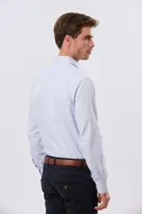 Camisa de vestir de manga larga con diseño de rayas finas celestes y blancas, cuello clásico y cierre frontal con botones. Incluye pequeño logo bordado en el pecho.