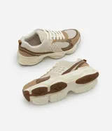 Championes estilo dad sneaker color beige, blanco y marrón, con cordones y suela alta.