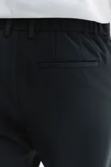 Pantalón sastrero negro de corte slim fit, con presillas para cinto, bolsillos laterales al bies y bolsillos traseros ojalados.
