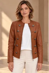 Campera de cuero ovino color beige, estilo napoleón, con cuello redondo, cierre frontal y botones metálicos decorativos en formato militar.
